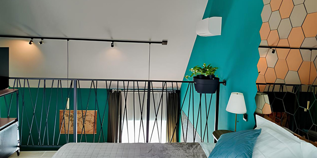 Lit confortable avec coussins bleus et décoration murale moderne dans une suite privative