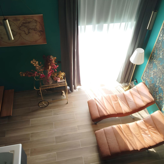 Chaises longues en cuir, décoration murale florale, et lumière naturelle dans un espace détente privatif