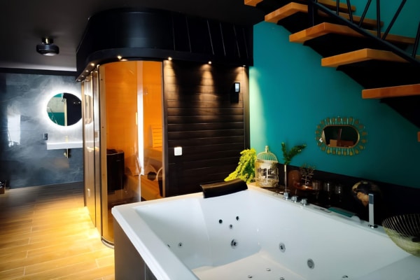 Bain à remous luxueux, sauna en bois vitré, et décoration élégante dans une suite privative
